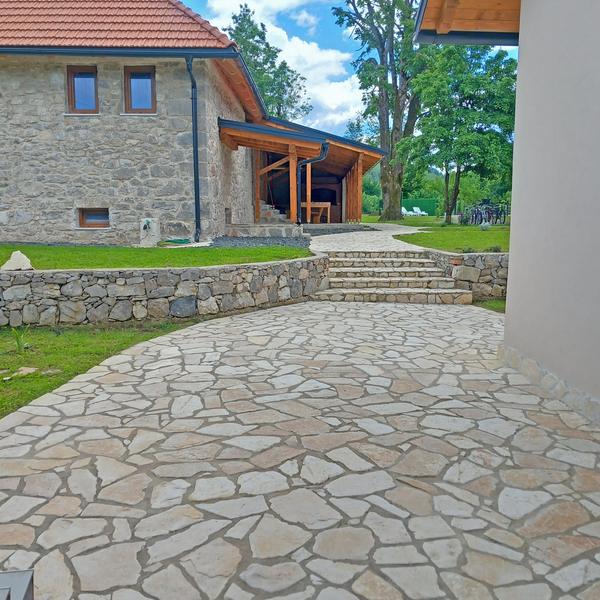 Kamenom popločeno dvorište ispred kamene kuće
